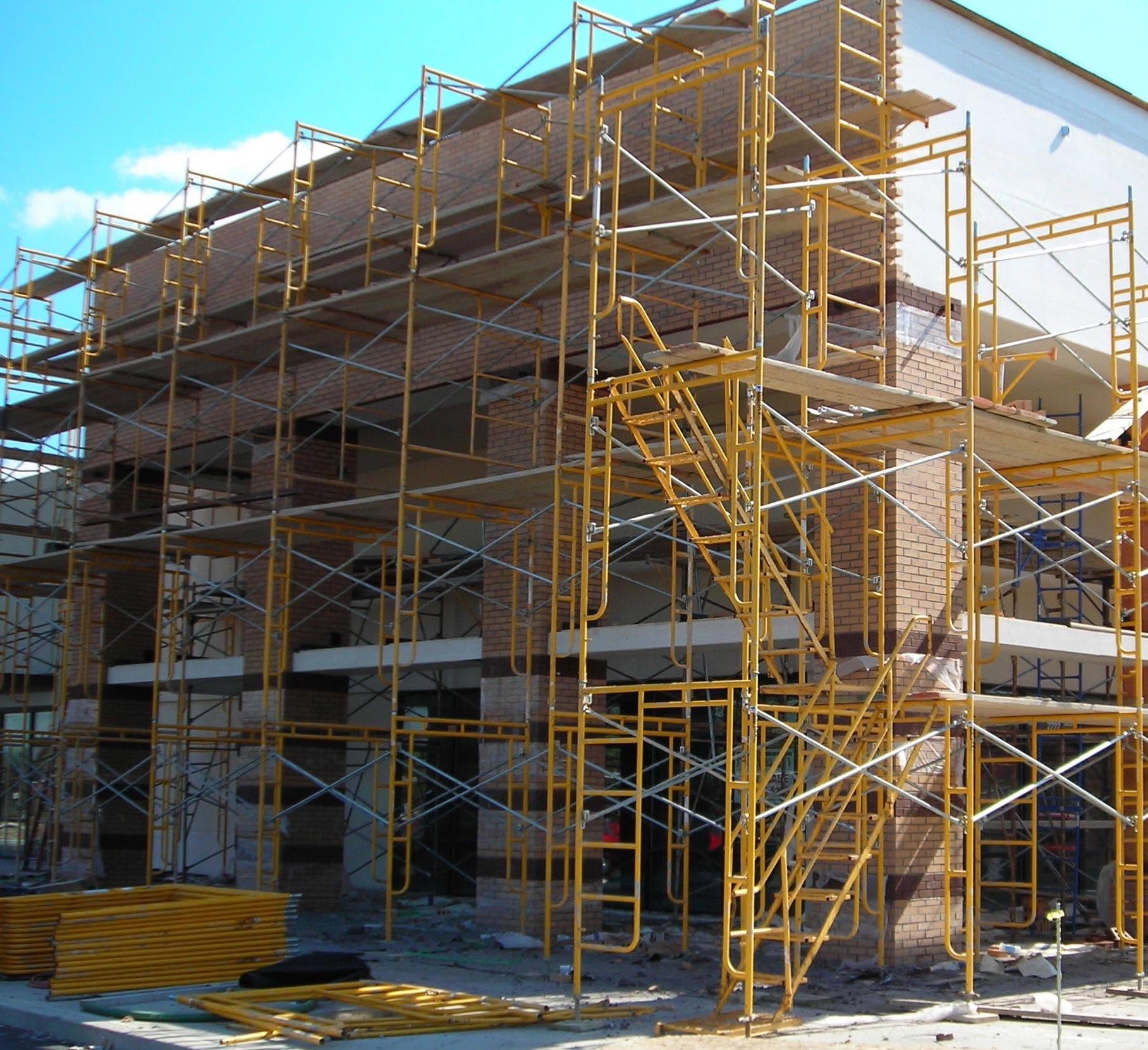 Building under construction with scaffolding in place against a blue sky